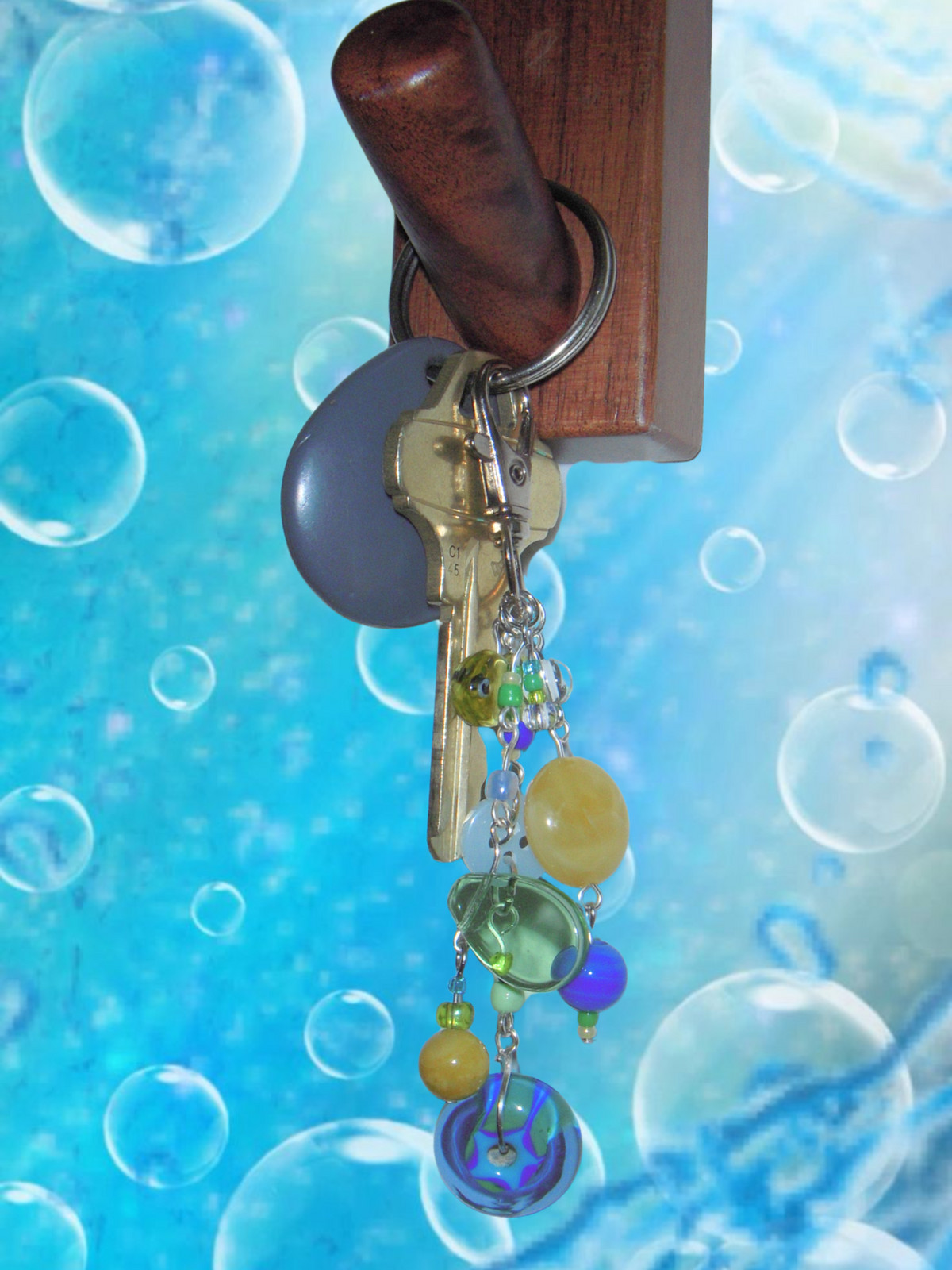 Wooden key holder with keychain against a blue bubble background