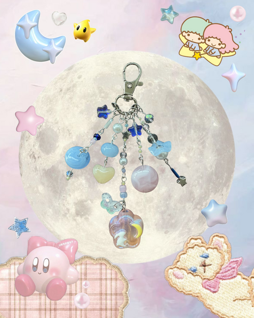 Keychain with charms against a colorful background featuring cartoon characters and a moon.
